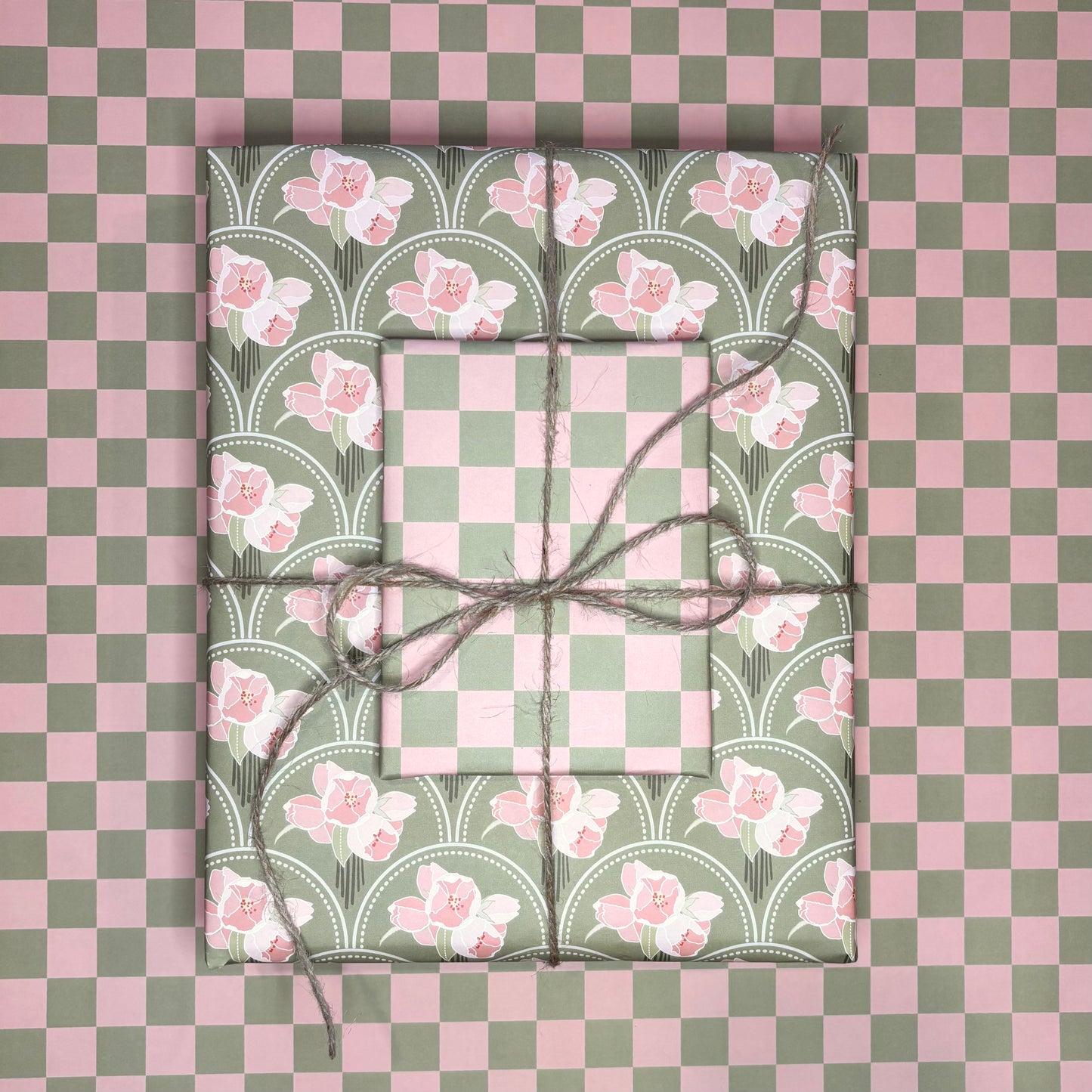 Two wrapped presents with floral patterns on a checkered pink and green background