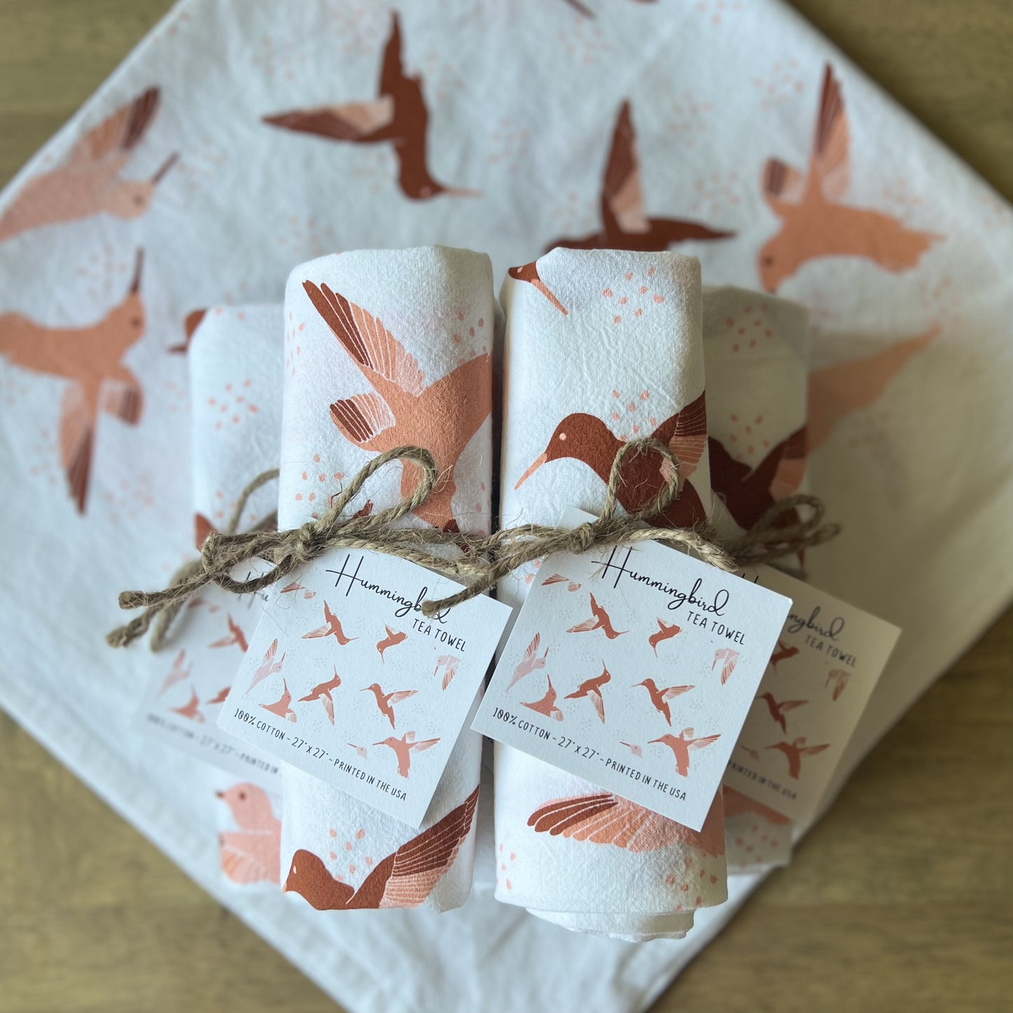 Stack of rolled hummingbird tea towels, tied with twine and hang tags