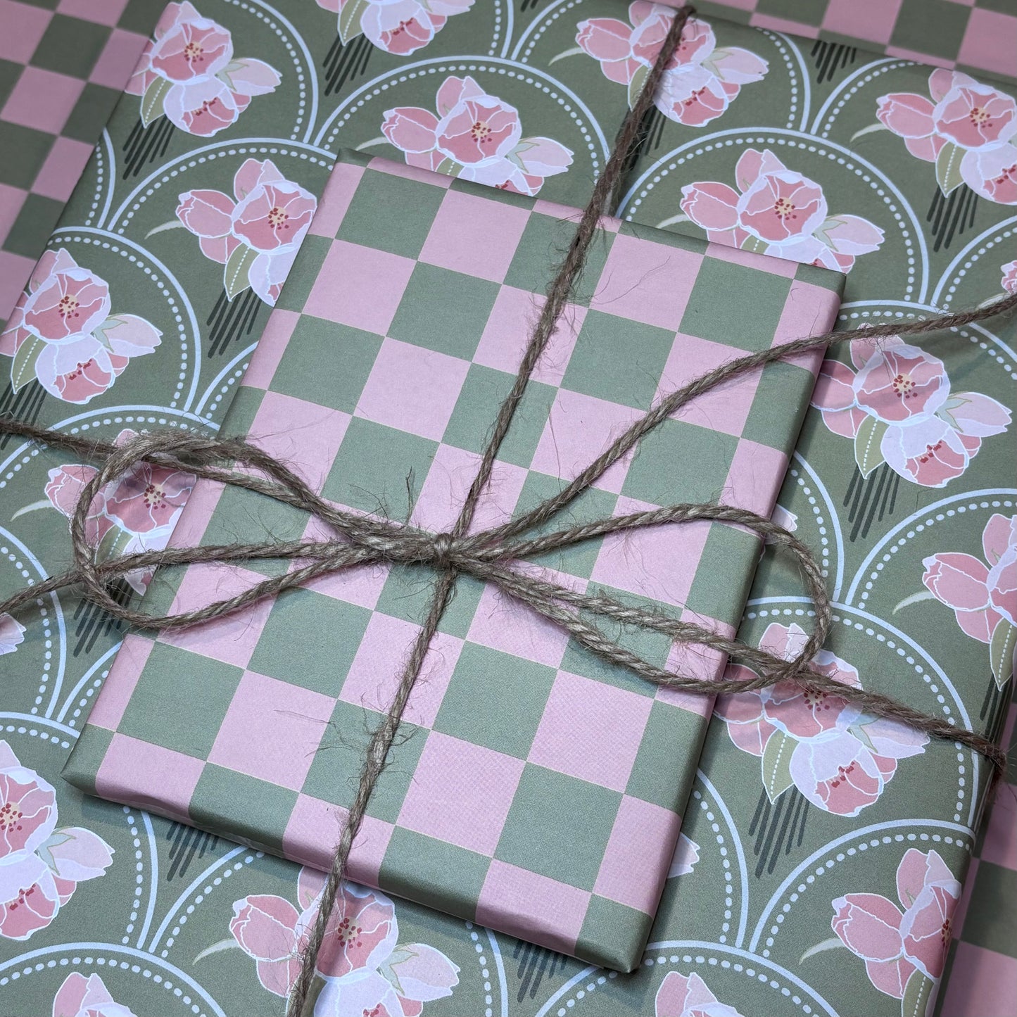 Gift boxes wrapped in pink and green check and floral wrapping paper tied with brown twine