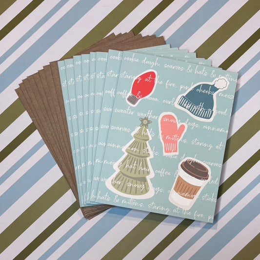 Stack of greeting cards with winter-themed illustrations on a striped background