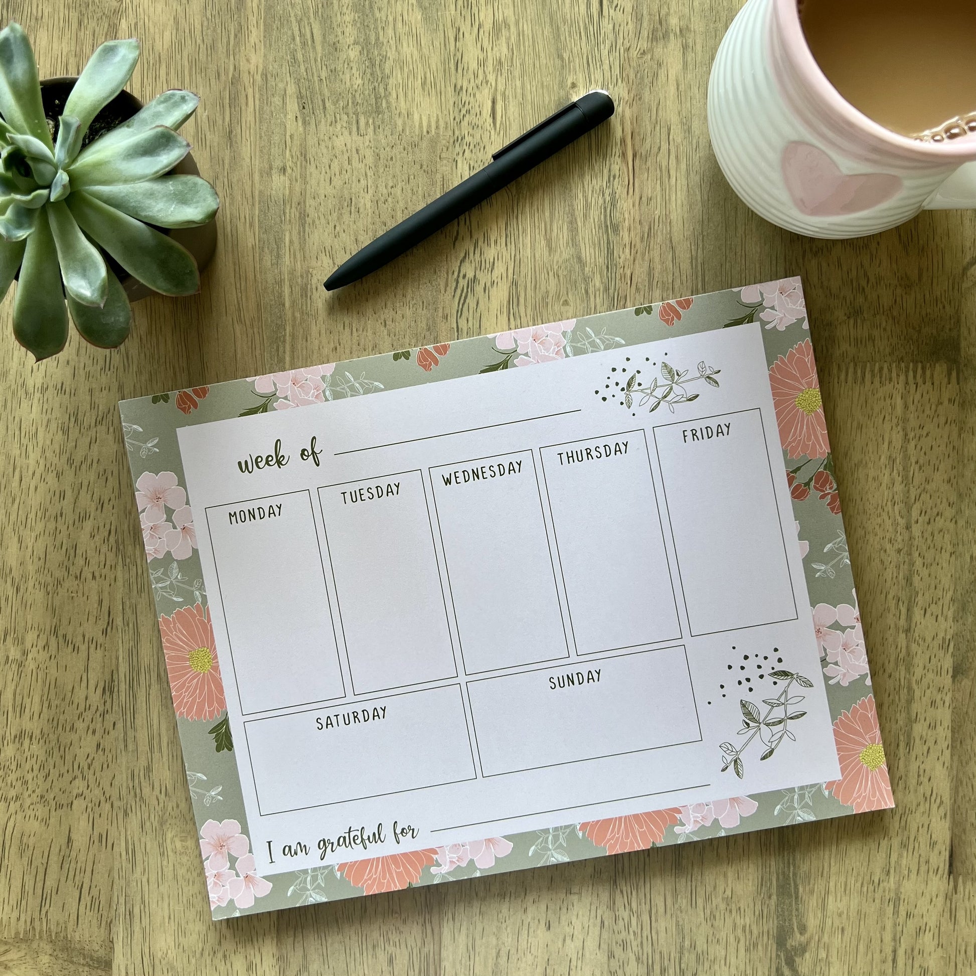 notepad with floral border, light pink writing area and a grid with boxes to write notes for each day of the week, plus a blank "I am grateful for" section at the bottom