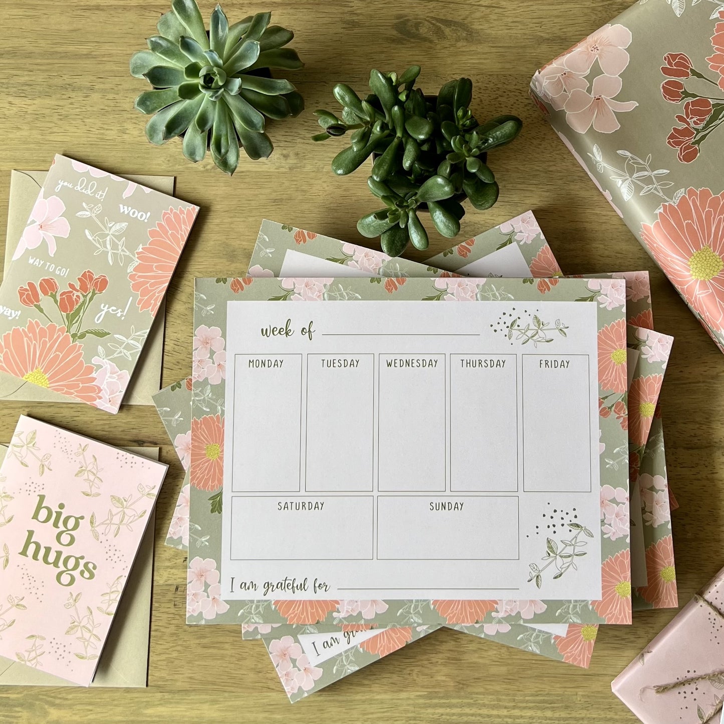 Pile of weekly planners styled with coordinating pattern items, cards and wrapping paper