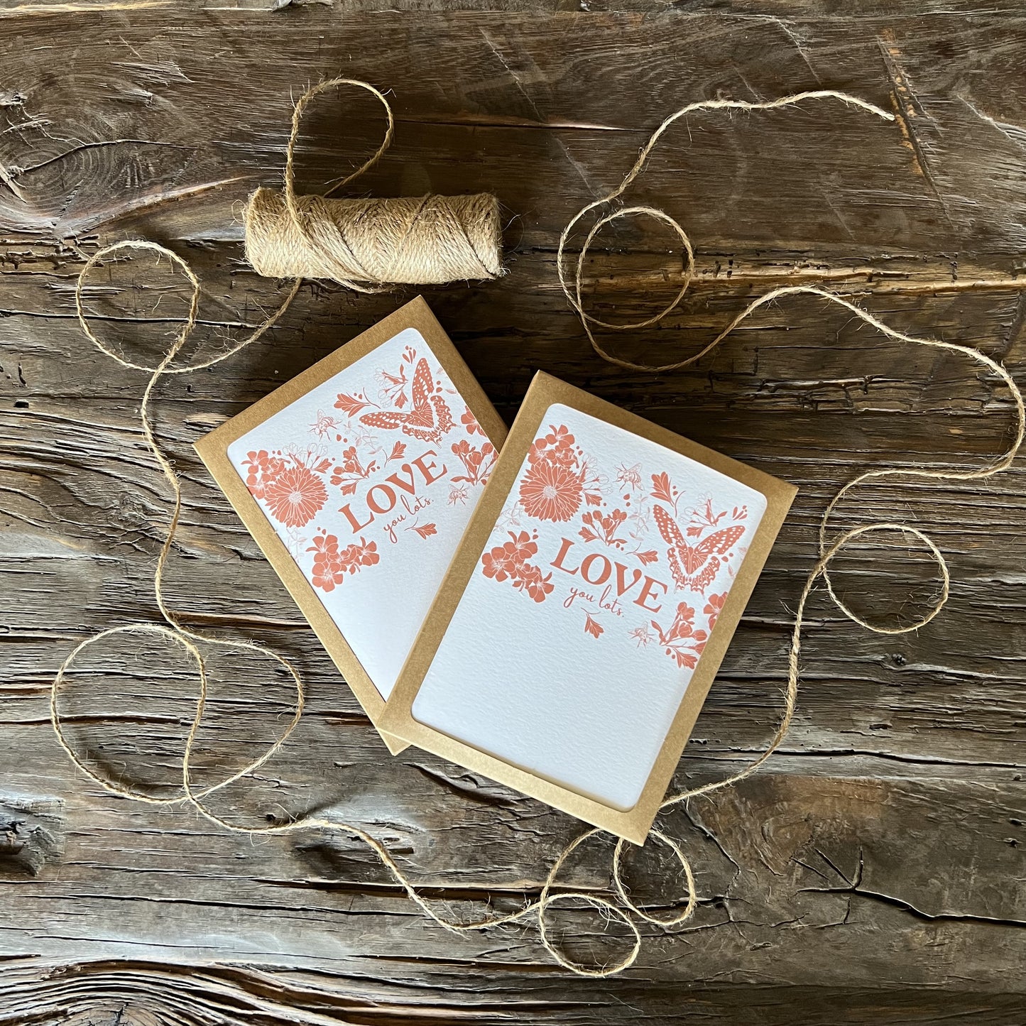 two boxes of white cards with butterflies, bees and flowers and the words "LOVE you lots" printed in dark pink ink