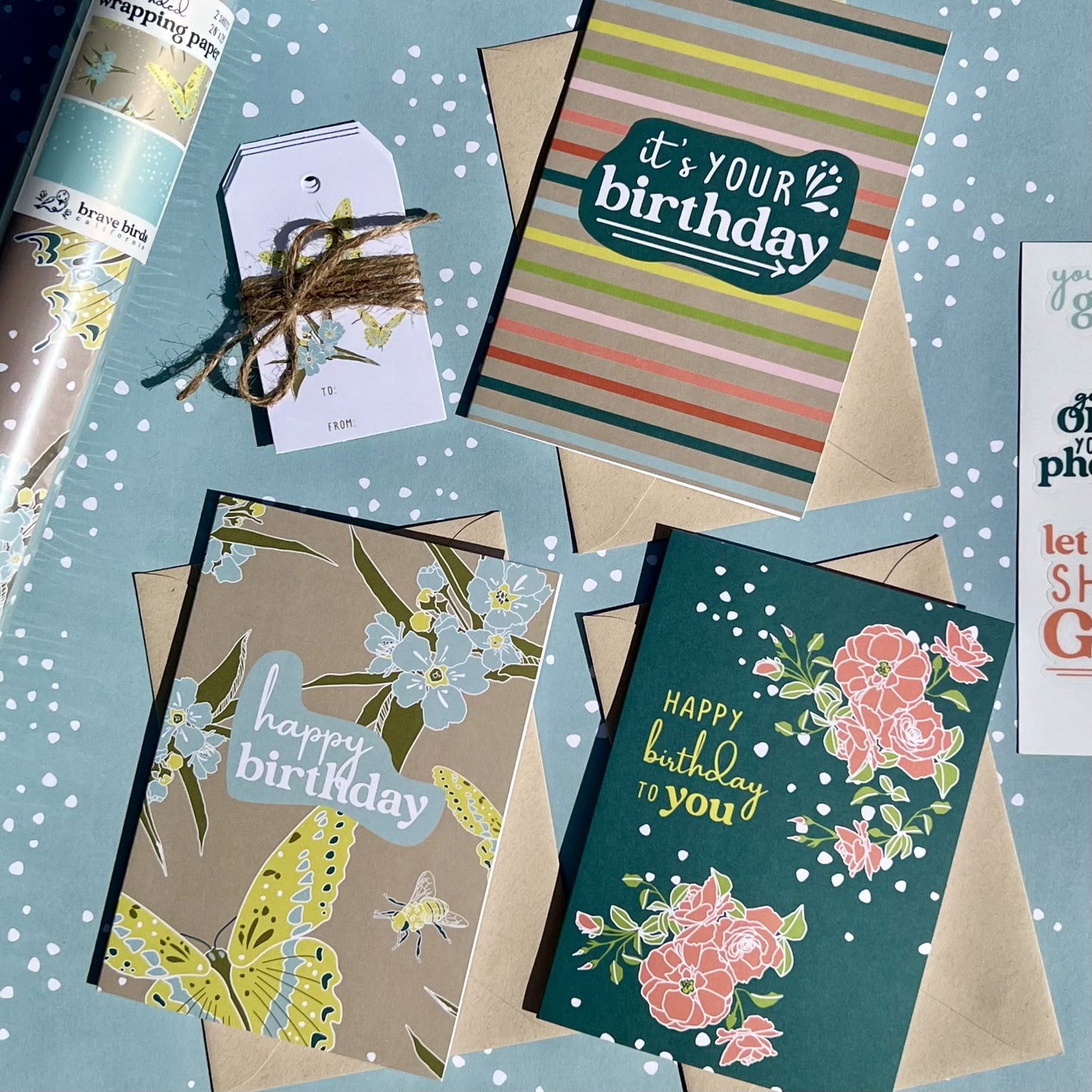 Assortment of 3 Birthday greeting cards, layed on top of wrapping paper