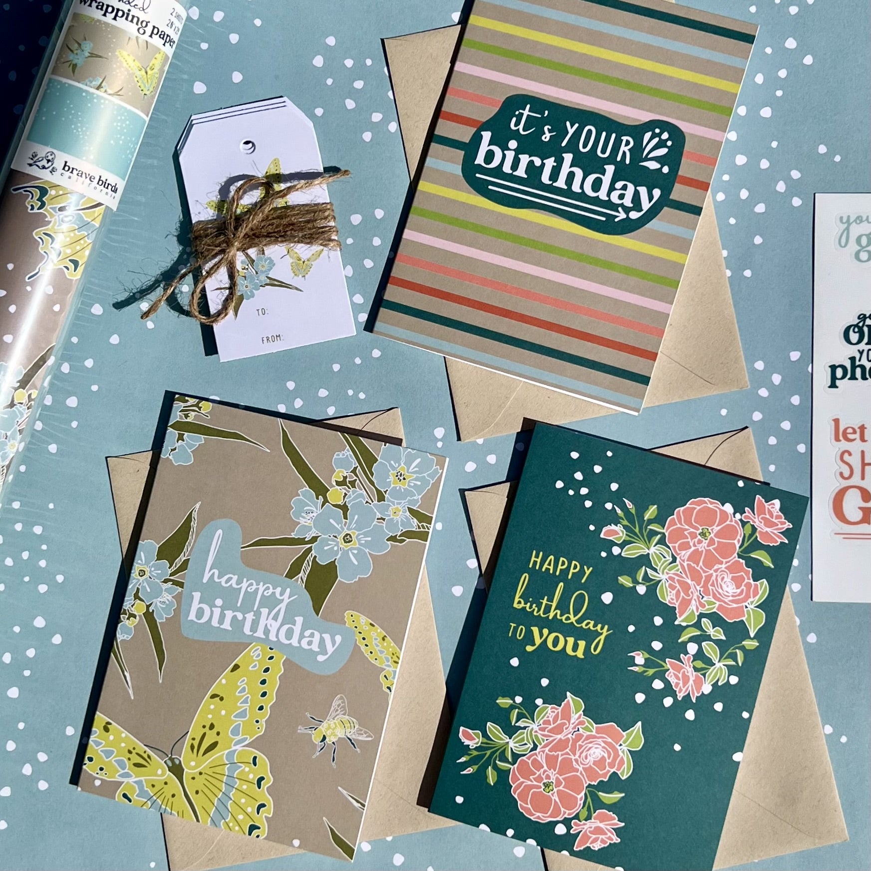 Assortment of 3 Birthday greeting cards, layed on top of wrapping paper