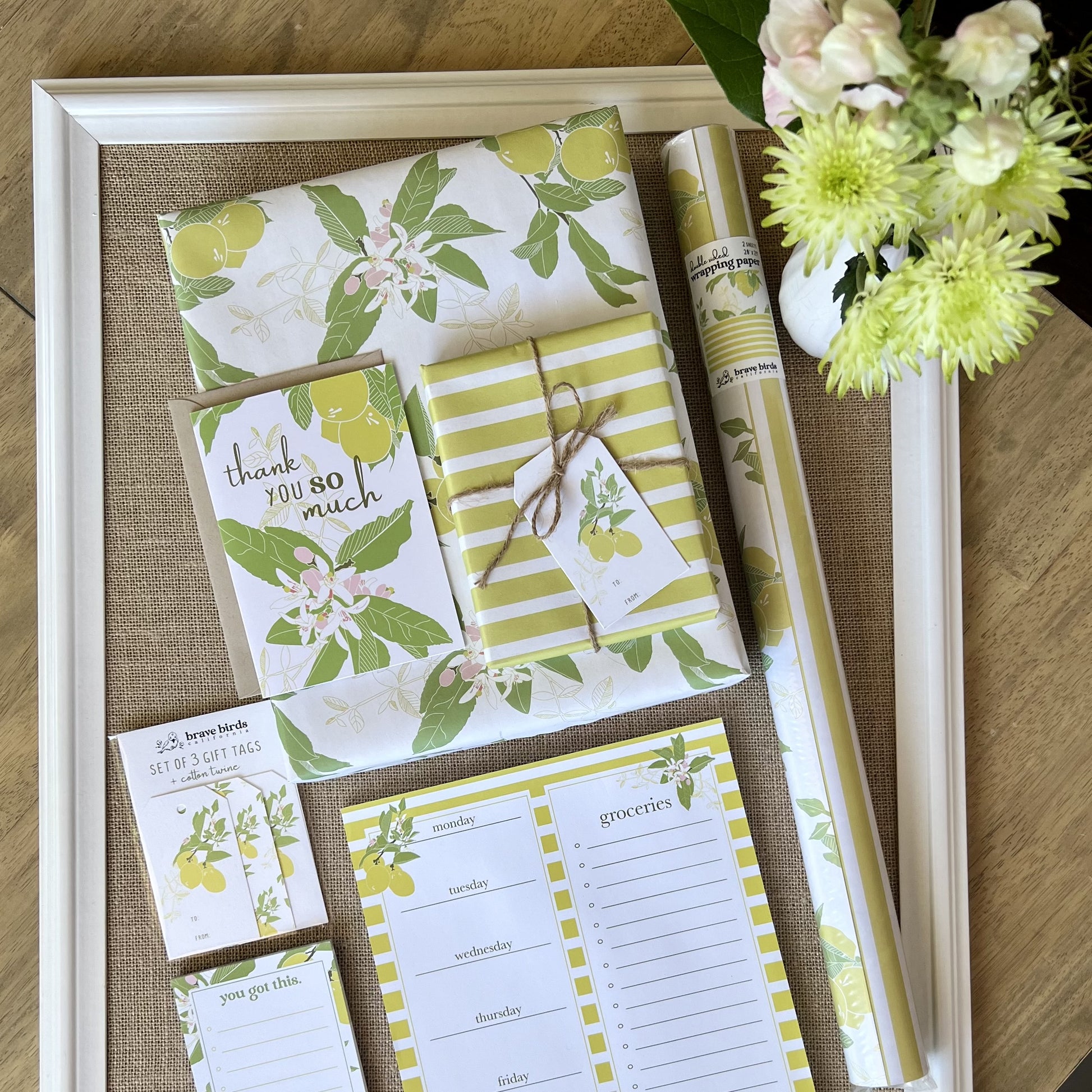 Collection of coordinated yellow, white and green lemon printed stationery products - gift wrap, gift tags, cards, notepads, styles with fresh flowers