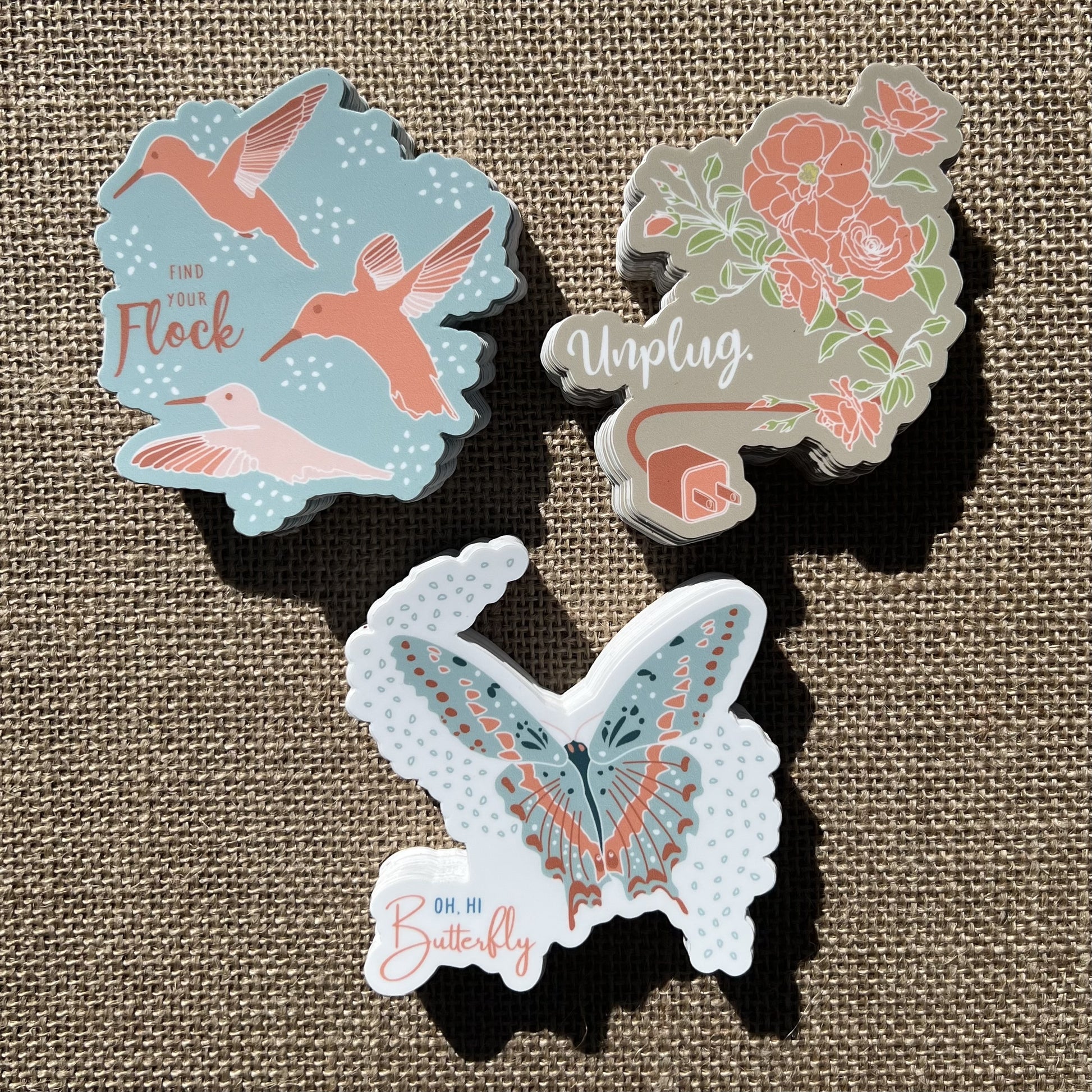 Set of 3 stickers - hummingbird, butterfly and rose, styled on a khaki linen background
