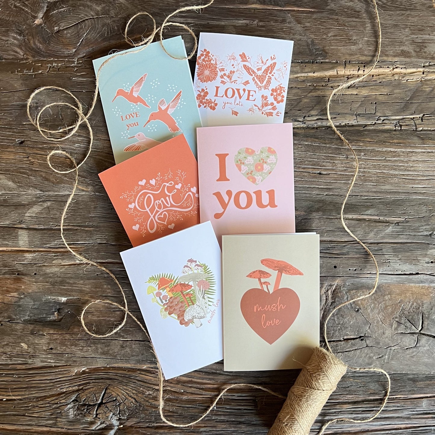 Collection of six assorted valentine cards, on a wooden background, styled with twine