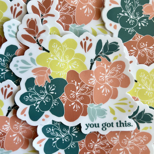 pile of stickers featuring a floral illustration in pink, teal and yellow with the words "you got this."