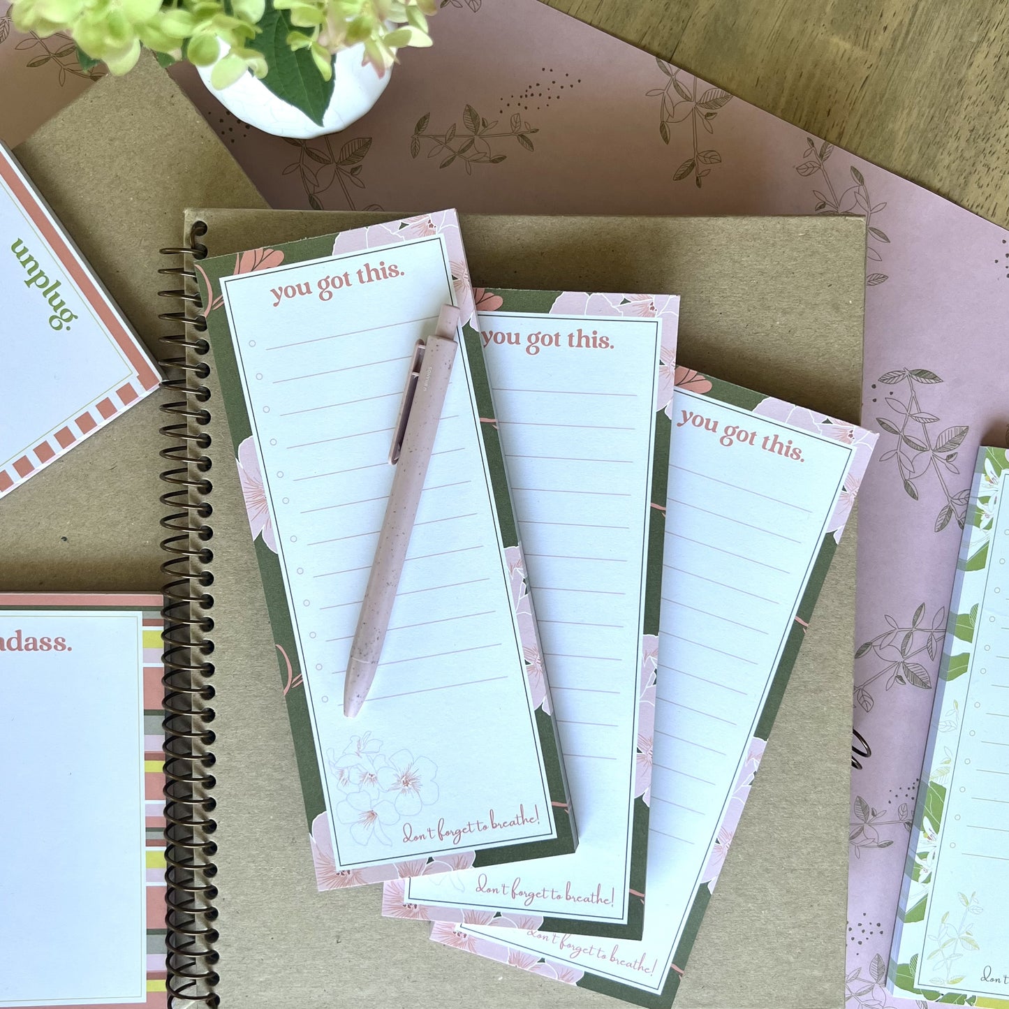stack of 3 you got this notepads, styled with a pink pen, and other stationery items