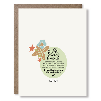 Back view of a greeting card with floral detail, showing Brave Birds California logo and the text "stationery & gifts with a healing mission: 10% of every purchase fights pediatric cancer."
