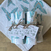 Load image into Gallery viewer, Rolled up stack of butterfly tea towels, tied with twine and hang tags
