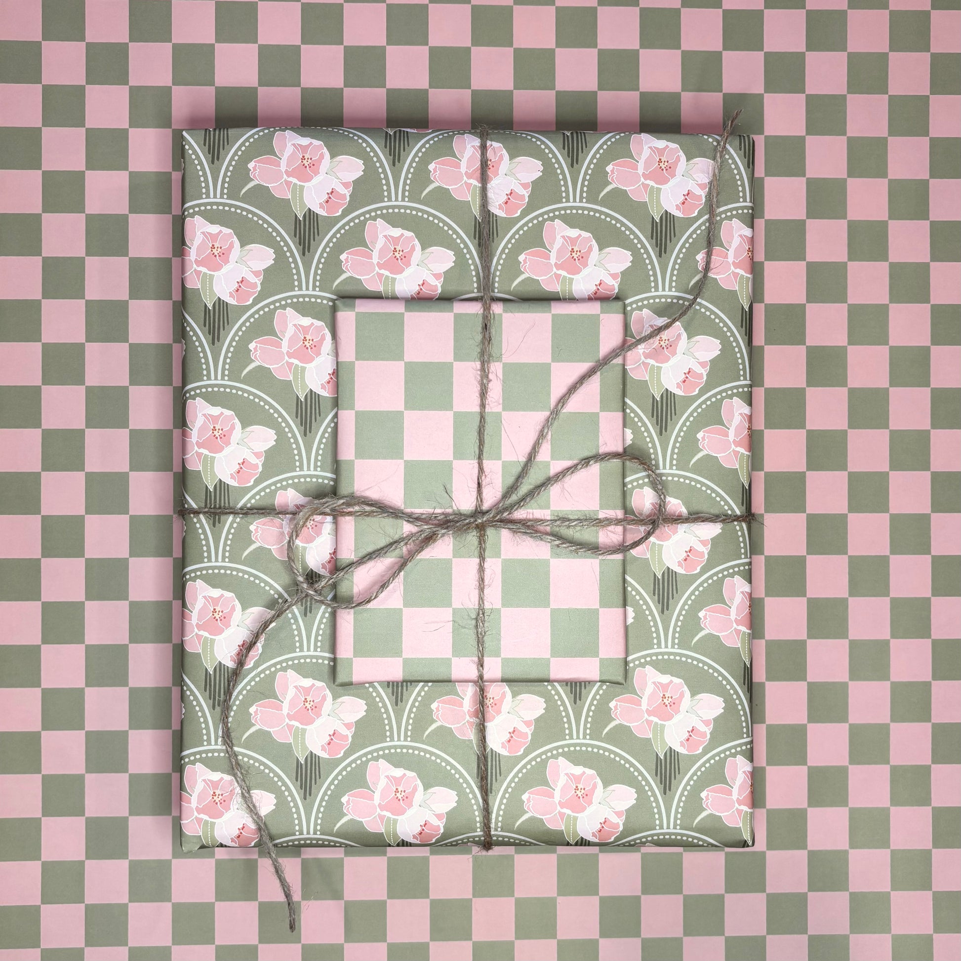 Two wrapped presents with floral patterns on a checkered pink and green background
