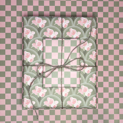 Two wrapped presents with floral patterns on a checkered pink and green background