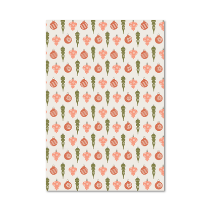 Gift wrap sheet featuring a repeating Christmas ornament pattern in coral pink, sage green, and cream.