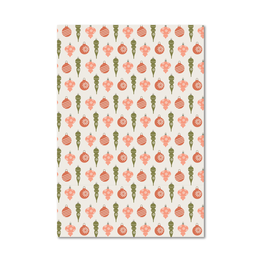 Gift wrap sheet featuring a repeating Christmas ornament pattern in coral pink, sage green, and cream.