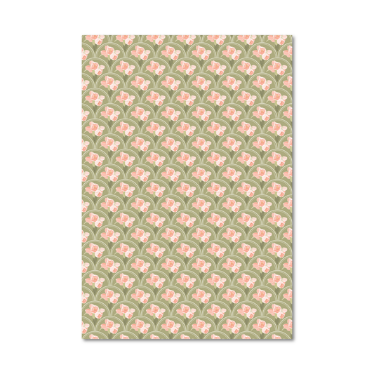 Patterned gift wrap sheet with a green background and pink flowers inside a white scallop shaped repeat design