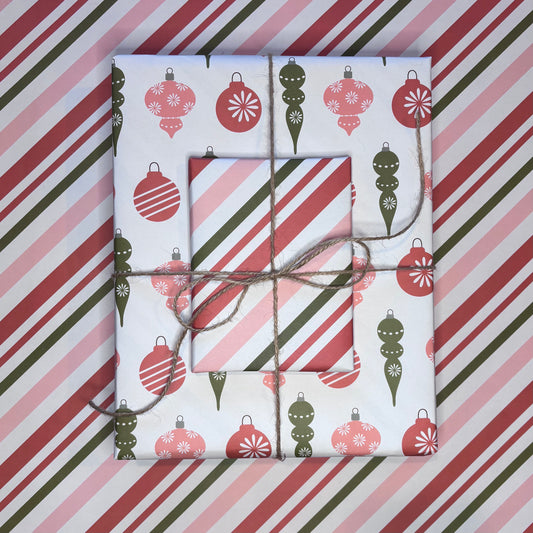 Gift boxes wrapped in festive candy cane stripe and ornament print red and green wrapping paper