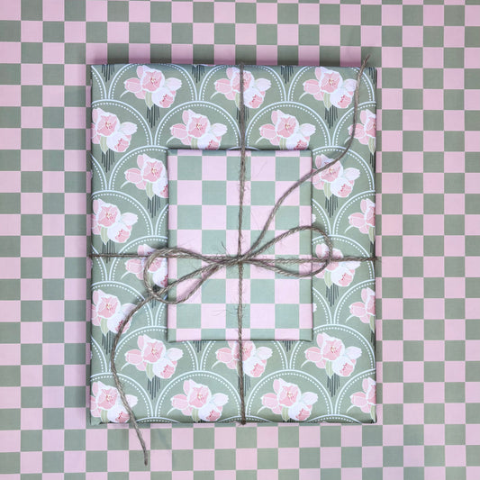 Two wrapped presents with floral patterns on a checkered pink and green background