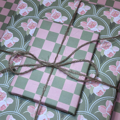 Gift boxes wrapped in pink and green check and floral wrapping paper tied with brown twine