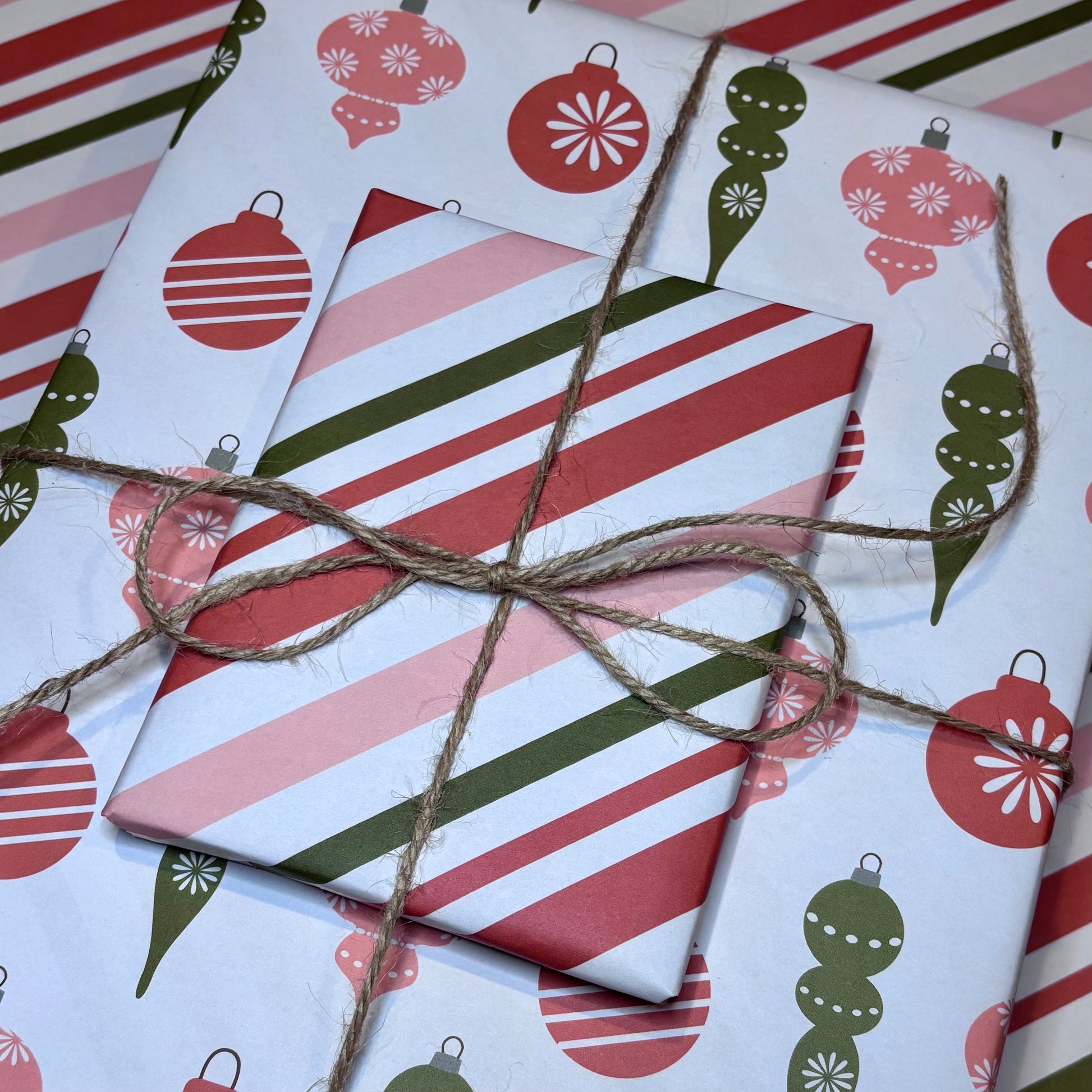 Gift wrapped in red, green, and white striped paper with a christmas ornament pattern.