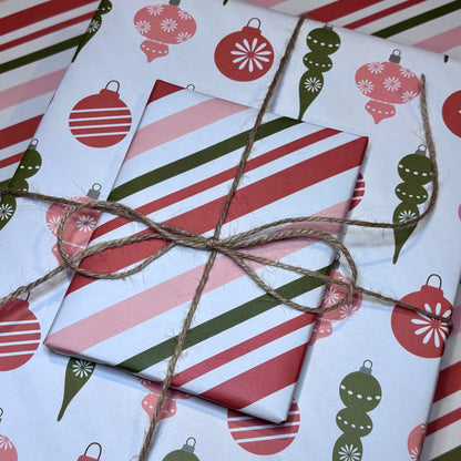 Gift wrapped in red, green, and white striped paper with a christmas ornament pattern.