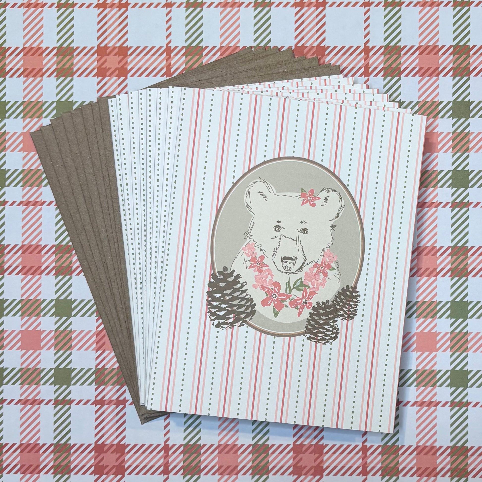 Stack of cards with bear illustration on a plaid background