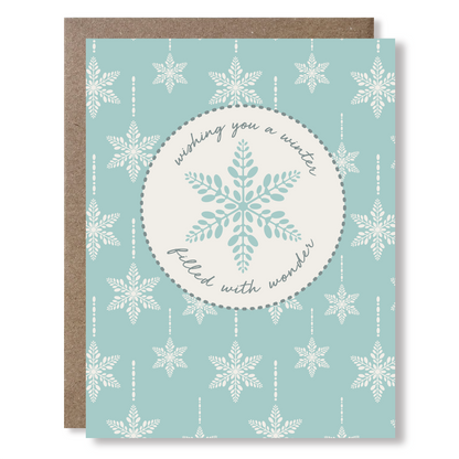 Greeting card with snowflake design and text on a light blue background saying 'wishing you a winter filled with wonder'