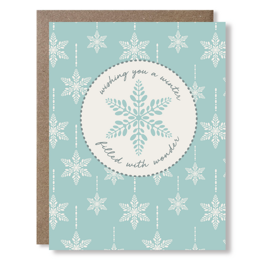 Greeting card with snowflake design and text on a light blue background saying 'wishing you a winter filled with wonder'