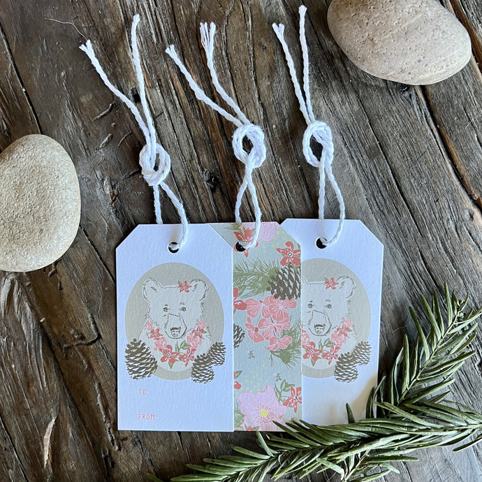 Set of three TO/FROM gift tags with floral bear illustrations on the front and allover floral print on the back. Each tag has white cotton twine laced through a hole at the top.