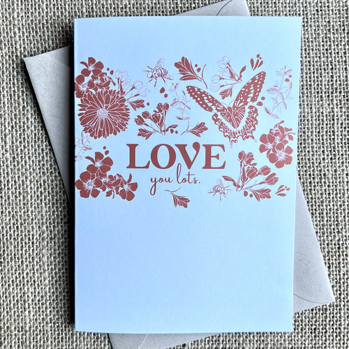 Greeting card with a white background and a dark pink illustration of flowers, bees and a buttefly with the text reading 