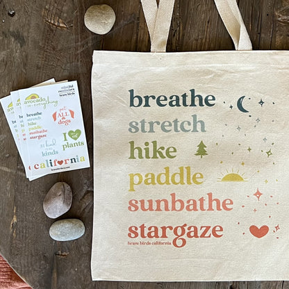 Get Outside Tote in rainbow colored ink shown styled with our California sticker sheet, in similar bright rainbow colored text.