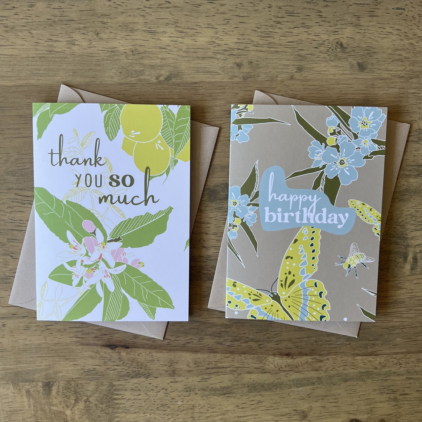Two greeting cards, one says thank you so much with lemon tree illustration, the other says happy birthday with butterfly, bee & flower illustration