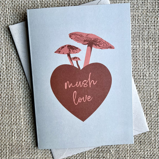 Khaki background greeting card with a red heart and pink mushrooms, text reading "mush love"