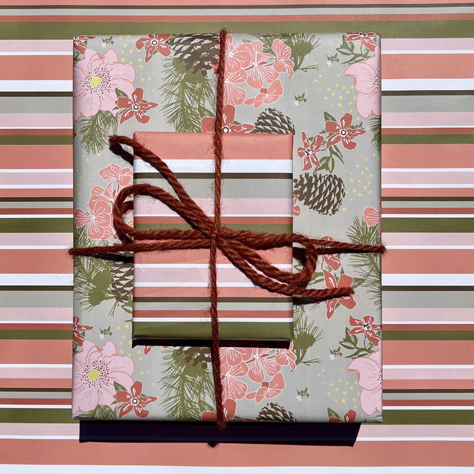 Giftwrapped package with two boxes, one in a pink & olive floral pattern with pinecones, one in a pink & olive stripe
