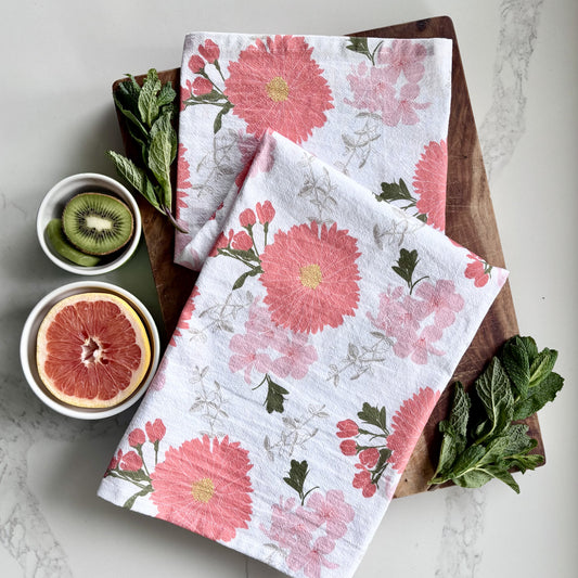 Pink floral tea towel on a wood cutting board, styled with fresh grapefruit, kiwi and mint