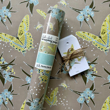 Load image into Gallery viewer, Packaged roll of wrapping paper  sitting on a flat sheet of the paper showing the full pattern, shown with coordinating gift tags
